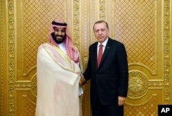 FILE - Turkey's President Recep Tayyip Erdogan, right, shakes hands with Saudi Crown Prince Mohammed bin Salman in Jiddah, Saudi Arabia, July 23, 2017.