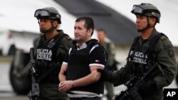 Un narcotrafiquant colombien de drogues, Daniel Barrera, escorté, avant son extradition aux États-Unis, à la base antidrogue de Bogota, en Colombie, le 9 juillet 2013.