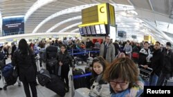 Passengers queue in Terminal 5 at Heathrow Airport in west London December 21, 2010. Snow and freezing temperatures continued to ground flights to and from Britain on Tuesday, with travellers hoping to get away for Christmas likely to suffer delays and c