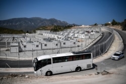 Les premiers groupes de réfugiés et de migrants sont transférés en bus vers le nouveau RIC de Samos, le premier des cinq nouveaux camps de migrants « fermés », sur l'île de Samos, en Grèce, le 20 septembre 2021.