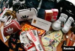 FILE - Counterfeit branded fashion goods are presented during the annual news conference of the customs duty office at Frankfurt Airport, outside Frankfurt, Germany..