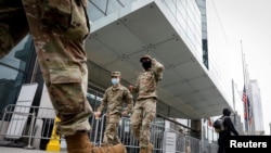 Militares estadounidenses enmascarados con tapabocas en la entrada del centro Javits de Nueva York, que ha sido convertido temporalmente en un hospital debido a la pandemia.