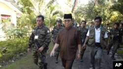 MILF leader Murad is escorted by his followers at the rebels' main camp in Camp Darapanan in southern Philippines, February 5, 2011