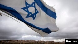 An Israeli flag flies on a hill near the West Bank Jewish settlement of Elazar, near Bethlehem March 17, 2013. U.S. President Barack Obama is due to make his first official visit to Israel and the Palestinian Territories this week, looking to improve ties