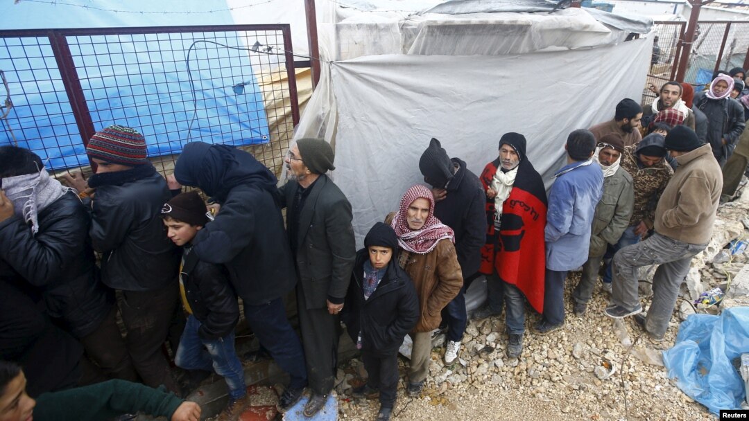 Internally displaced Syrians line up to receive blankets near the Bab al-Salam crossing, across from Turkey's Kilis province, on the outskirts of the northern border town of Azaz, Syria, Feb. 6, 2016. 