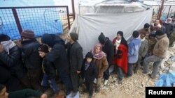 Internally displaced Syrians line up to receive blankets near the Bab al-Salam crossing, across from Turkey's Kilis province, on the outskirts of the northern border town of Azaz, Syria, Feb. 6, 2016. 