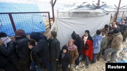 FILE - Internally displaced Syrians line up to receive blankets near the Bab al-Salam crossing, across from Turkey's Kilis province, on the outskirts of the northern border town of Azaz, Syria, Feb. 6, 2016. 