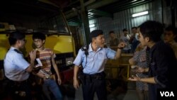 在香港旺角商业区的一场本土派示威中，警察检查“本土民主前线”的发言人黄台仰（左起第二人）的身份证（2015年6月21日）