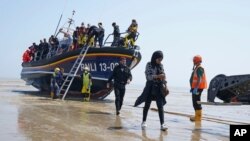 Sekelompok orang yang diduga migran yang menyeberang dari Perancis menggunakan sekoci tiba di Dungeness, wilayah selatan Inggris, pada 20 Juli, 2021. (Foto: Gareth Fuller/PA via AP)