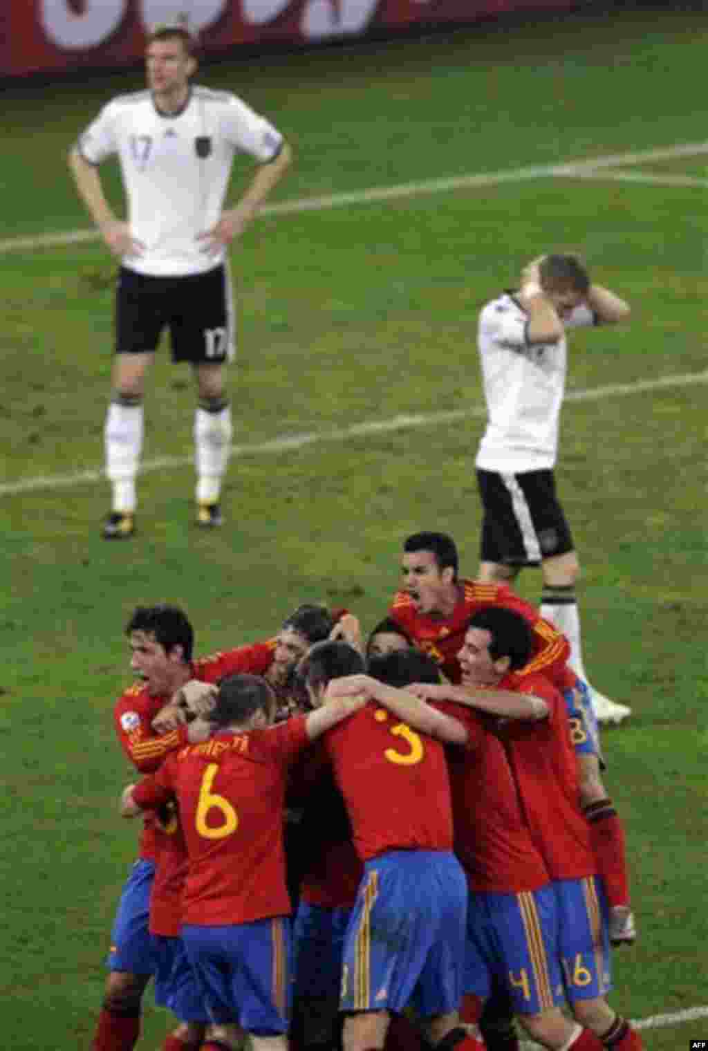 Spain's Carles Puyol is hidden by celebrating teammates after scoring their first goal during the World Cup semifinal soccer match between Germany and Spain at the stadium in Durban, South Africa, Wednesday, July 7, 2010. (AP Photo/Hassan Ammar)