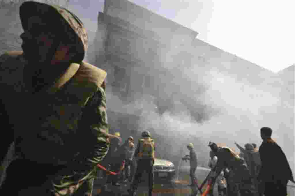 Egyptian army soldiers fight a fire believe to be set by hundreds of low-ranking police at a part of the security headquarters in Cairo, Egypt, Wednesday, Feb.23, 2011, after four days of protests to demand better salaries.A security official says the pr