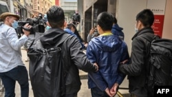 FILE - Ben Chung, 2nd right, of a pro-democracy political group is arrested by police in the Central district after as many as 50 Hong Kong opposition figures were arrested in Hong Kong, Jan. 6, 2021.