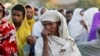 FILE - A woman stands in line with others to receive food donations at a school, which was turned into a temporary shelter for people displaced by conflict, in the town of Shire, in Ethiopia's Tigray region, March 15, 2021.