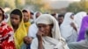 FILE - A woman stands in line with others to receive food donations at a school, which was turned into a temporary shelter for people displaced by conflict, in the town of Shire, in Ethiopia's Tigray region, March 15, 2021.
