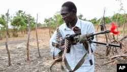 An opposition fighter walks with his weapon on which is tied a red ribbon, signifying danger as a warning to government forces and a willingness to shed blood, according to an opposition spokesman, in Akobo town, South Sudan, Jan. 21, 2018.