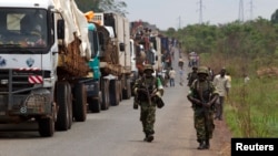 FILE - African Union peacekeepers guard a commercial convoy making its way to the border of Cameroon, near Bangui, Central African Republic, March 8, 2014.