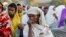FILE - A woman stands in line with others to receive food donations at a school, which was turned into a temporary shelter for people displaced by conflict, in the town of Shire, in Ethiopia's Tigray region, March 15, 2021.