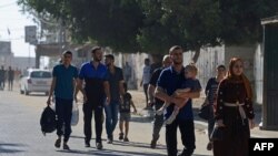 FILE - Residents in the Gaza Strip flee their homes to move away from the border with Israel after barrages of rockets were fired from the coastal enclave into Israel on October 7, 2023.