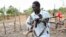 An opposition fighter walks with his weapon on which is tied a red ribbon, signifying danger as a warning to government forces and a willingness to shed blood, according to an opposition spokesman, in Akobo town, South Sudan, Jan. 21, 2018.