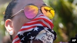 Una manifestante usa un pañuelo con el diseño de la bandera estadounidense durante una protesta por la muerte de George Floyd en Los Ángeles el 30 de mayo de 2020.