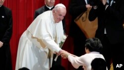 El papa Francisco recibe una flor después de dar un discurso en la Universidad Sophia en Tokio, el martes, 26 de noviembre de 2019.