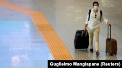 Italy, Rome, A passenger wearing a protective face mask walks at Fiumicino Airport