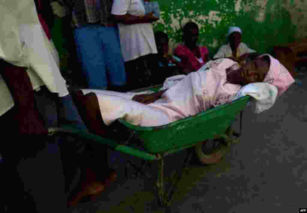 A woman suffering cholera symptoms is pushed in a wheelbarrow to St. Catherine hospital, run by Doctors Without Borders, in the slum of Cite Soleil in Port-au-Prince, Haiti, Wednesday, Nov. 17, 2010. A month-old cholera epidemic has killed at least 1,000 