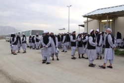 FILE - Taliban prisoners stand before being released from the Bagram prison next to the U.S. military base in Bagram, some 50 km north of Kabul, April 11, 2020, in this handout photo released by Afghanistan's (NDS) National Security Council.