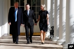 President Donald Trump walks with American Pastor Andrew Brunson and his wife, Norine, down the Colonnade of the White House before their meeting in the Oval Office, Oct. 13, 2018, in Washington.