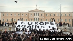 Para aktivis membentangkan spanduk bertuliskan "Eropa Menentang Neo-Nazi" dalam sebuah protes di depan Parlemen Yunani pada 15 Desember 2021 untuk menentang rasisme.(Foto: AFP/Louisa Gouliamaki)