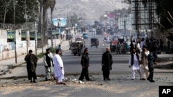 Afghan police officers inspect the scene after two bombs exploded at a Police checkpoint in the city of Jalalabad east of Kabul, Afghanistan, May 15, 2013.