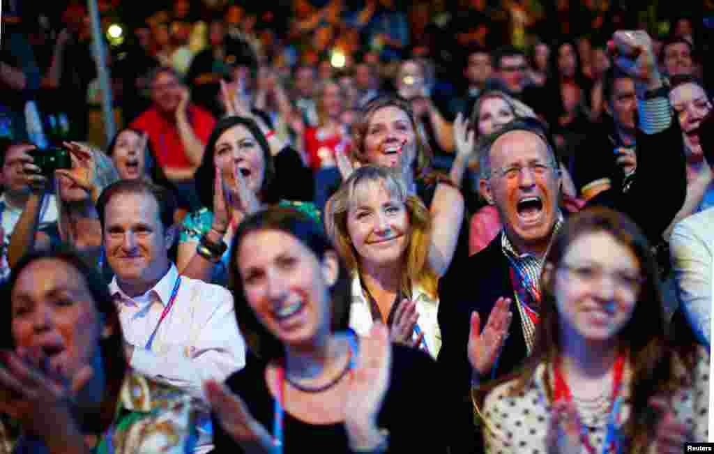 Os delegados comemoram quando vêem a imagem de Mitt Romney aparecer durante a sessão de abertura