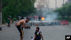 Protesters burn tires and block a street during a demonstration in Baghdad, Iraq, Oct. 1, 2019.