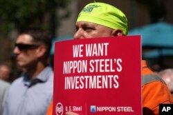 FILE - A supporter of a proposed takeover of U.S. Steel by Japan's Nippon Steel participates in a rally by U.S. Steel employees in downtown Pittsburgh, Pennsylvania, on Sept. 4, 2024.