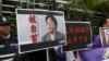 香港民主抗议者举着铜锣湾书店老板桂民海（左）和李波（右）的肖像（2016年1月19日）。