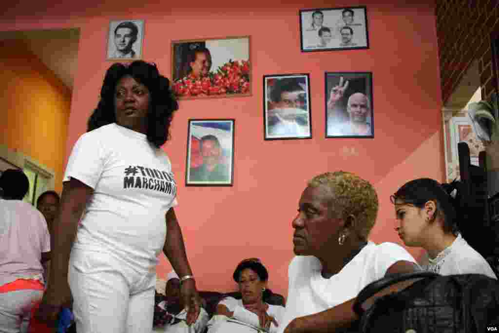 Berta Soler stands in front of a wall in the Ladies in White headquarters, which honors opposition members who were killed or died while carrying out activism in Havana, Cuba. (V. Macchi / VOA) 