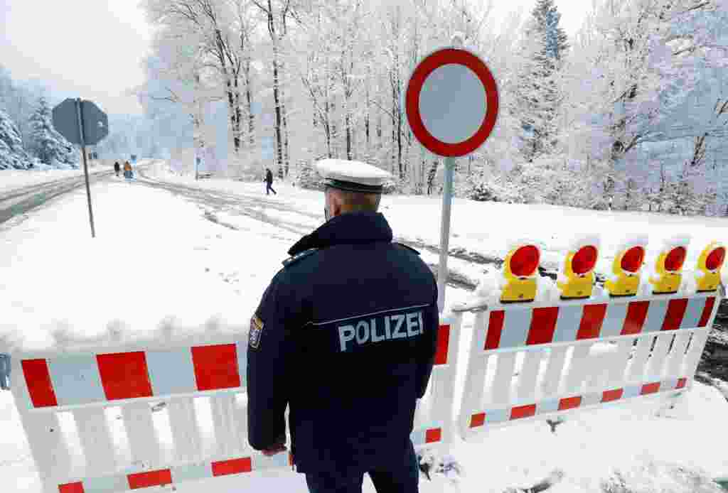 Një oficer policie ruan një postbllok në rrugën për në malin Feldberg ditën e Vitit të Ri ndërsa sëmundja e koronavirusit (COVID-19) vazhdon, në Koenigstein, pranë Frankfurtit, Gjermani, 1 janar 2021. REUTERS / Ralph Orlowski