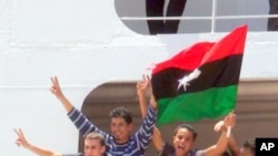 Young men in Benghazi celebrate their evacuation from Tripoli by the International Committee of the Red Cross, June 24 2011