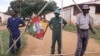 2000年4月10日，在哈拉雷以北约60公里的马佐夫，警察和黑人占领者守卫着被驱逐的白人农民的农场。罗伯特·穆加贝总统的一幅肖像挂在篱笆上。议会通过法案，授权政府在没有支付赔偿的情况下夺取白人土地。全国各地有1000个农场被占领。
