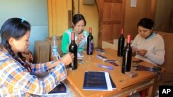 Workers label wine bottles at Aythaya wine estate in Aythaya, near Taunggyi, the capital of northeastern Shan state, Myanmar, Feb. 2, 2016.