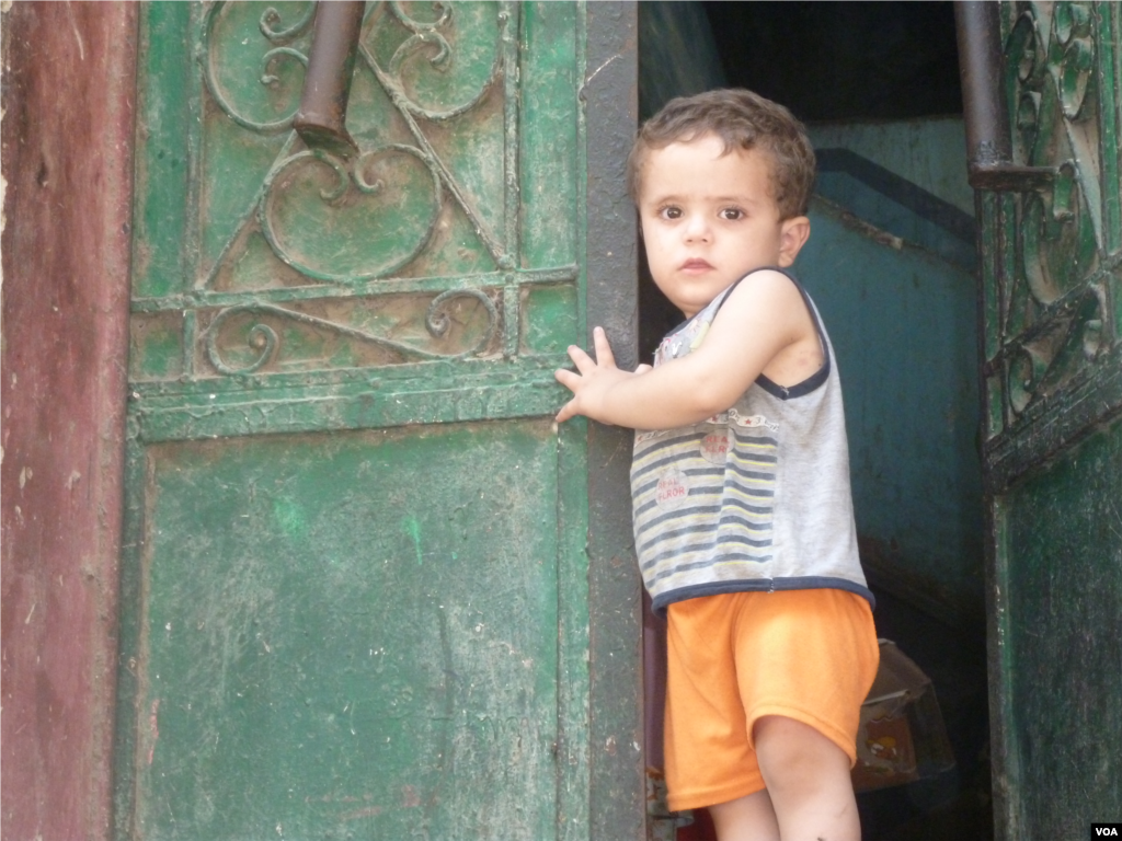 A boy stands at the entryway to a home in the area of Cairo known as Garbage City, where many of the minority Coptic Christians live, July 18, 2013. (VOA/S. Behn)