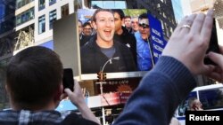 El fundador de Facebook, Mark Zuckerberg, aparece en las pantallas de Menlo Park, tras la salida a la venta de las acciones de la empresa de internet.