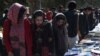 FILE - Visitors browse a book exhibition to mark International Women's Day at Kabul University, March 8, 2020. The Taliban say women have nothing to fear under their rule, but that's not how many educated Afghan women see it.