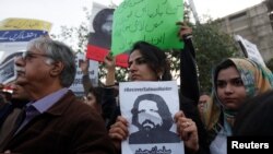 Human rights activists hold a picture of Salman Haider, who is missing, during a protest to condemn the disappearances of social activists in Karachi, Pakistan, Jan. 19, 2017.