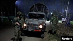 FILE - Greek security members patrol near Turkey's Pazarkule border crossing, in Kastanies, Greece, March 12, 2020.