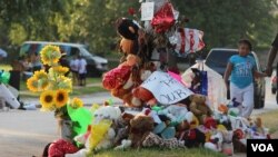 Barang-barang tanda penghormatan pada Michael Brown di Ferguson, Missouri. (VOA/Gesell Tobias)