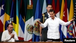 Mexico's President Enrique Pena Nieto greets the audience next to Mexico's Foreign Minister Luis Videgaray during the opening ceremony of OAS 47th General Assembly in Cancun, Mexico, June 19, 2017.