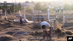 In photo taken Sept. 1, 2016, Uzbek workers clean an area of the central cemetery in Samarkand, Uzbekistan. Central Asian news website Fergana.ru on Friday posted pictures from Uzbekistan President Islam Karimov's hometown of Samarkand.