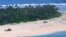 This handout photo taken Aug. 2, 2020 and released Aug, 4, 2020, by the Australian Defense Force shows an Australian Army helicopter landing near "SOS" signage on a beach on Pikelot Island where three missing sailors were found in good condition.
