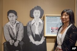 Shirley Ann Higuchi, chairman of the Heart Mountain Wyoming Foundation, stands next to a life-size photo of her parents taken in the camp.